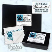 Display of multiple black glossy gift boxes with the Dazzling Paws Jewelry logo and a polishing cloth.