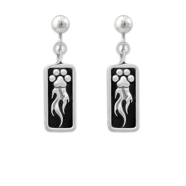 A pair of sterling silver earrings featuring a paw print design with flames shooting off it, attached to a rectangular black background.