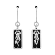 A pair of sterling silver earrings featuring a paw print design with flames shooting off it, attached to a rectangular black background.